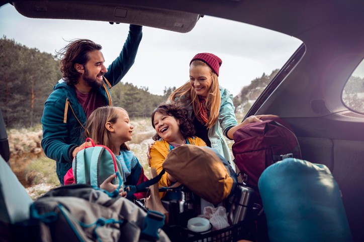 Close up of a young family getting the camping supplies out of the car