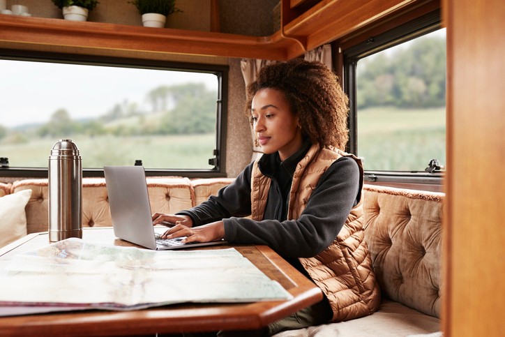 Young woman using laptop while sitting in camper van